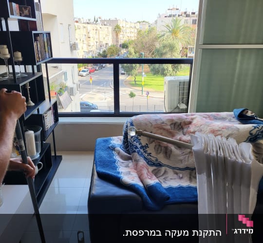 אדם מחזיק מוט אלומיניום עם וילון לבן